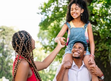 African American family having fun and spending good time together while walking outdoors on the street.